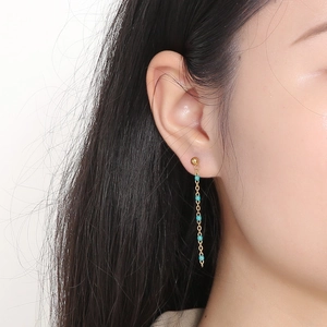 Long gold chain drop earrings with turquoise beads shown on a model profile