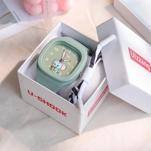 Macro detail of mint green square watch with cartoon elephant dial and silicone strap