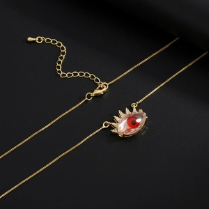Gold plated evil eye necklace with sun pendant and sparkling zircon on black background