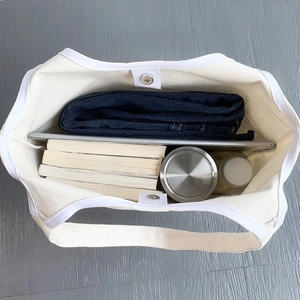 Macro detail of canvas tote bag interior with large storage capacity and magnetic buckle