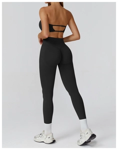 Detail of high waist black yoga set with ruched leggings and strappy open back sports bra
