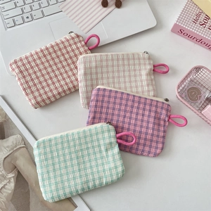 Detailed close-up of stackable seersucker plaid cosmetic pouches with zipper and side handle