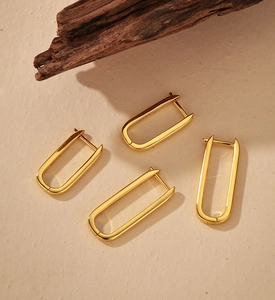 Detail view of gold U-shaped silver hoop earrings showing the S925 hallmark on polished finish