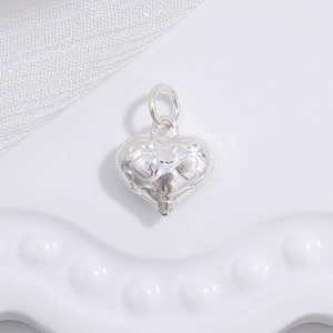 Macro shot of 925 silver heart pendant with textured grid pattern and hollow design