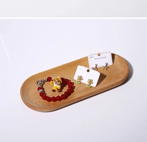 Detail view of squirrel bracelet and earrings in a minimalist oval wooden jewelry tray