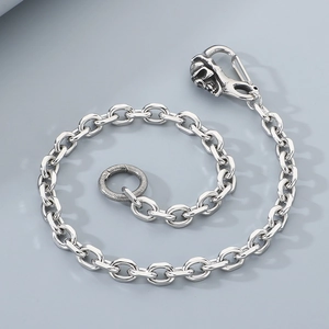 Detail of silver skull clasp and textured ring on a stylish punk metal trouser chain