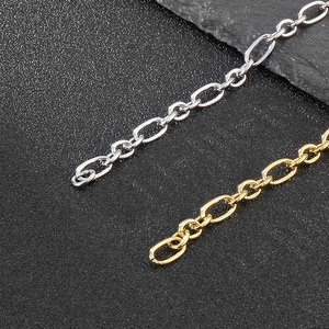 Macro detail of gold and silver stainless steel O-chains on a textured slate background
