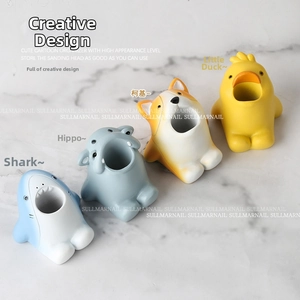 Detail view of cartoon shark, hippo, corgi, and duck storage holders for nail drill bits