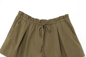 Detail of army green shorts with drawstring elastic waist and side pocket texture