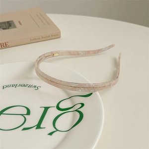 Close-up of pink marble acetate headband with anti-slip teeth and gold metal connector