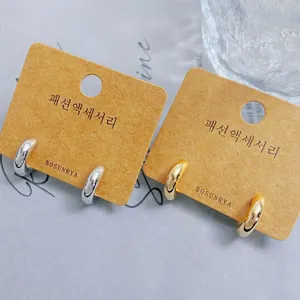 Minimalist C-shape small hoop earrings in gold and silver finish on display cards