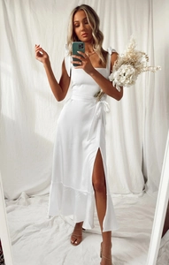 Detailed view of white satin dress featuring adjustable bow straps and side leg slit