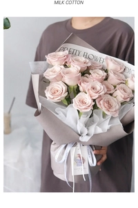 Detail of pink milk cotton flower wrapping paper with elegant white lining and satin ribbon