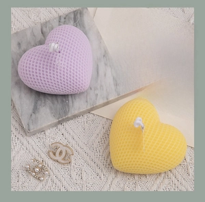 Detailed view of heart-shaped scented candles with grid texture in soft purple and yellow