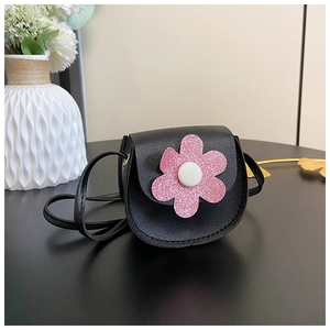 Detailed view of a black mini crossbody bag featuring a pink sequined flower decoration