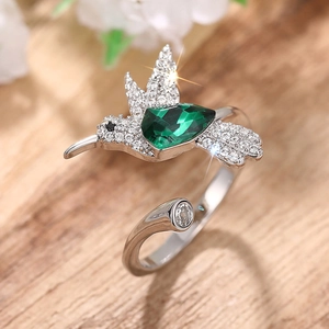 Macro-detail van kolibrie ring met groene edelsteen en zirkonia versieringen