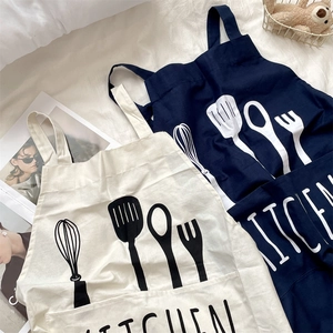 Macro view of minimalist cotton linen kitchen aprons with utensil prints and large pockets