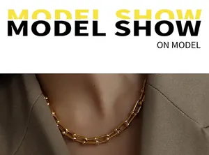 Close-up of gold U-link chain necklace with high-polish mirror finish shown on a model