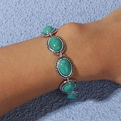 Detail of vintage turquoise bracelet with heart-shaped frames on a woman's wrist