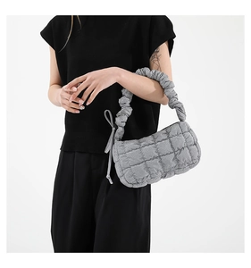 Detail of grey pleated cloud handbag with quilted texture and ruched handle on shoulder