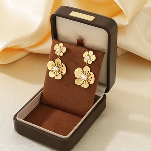 Detailed view of 18K gold floral earrings with pearls in a luxury jewelry gift box