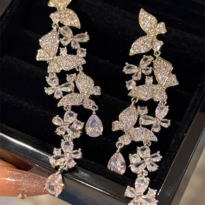 Detailed close-up of sparkling butterfly tassel earrings with pear-shaped rhinestones
