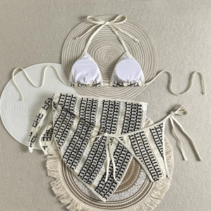 Vue à plat d'un ensemble bikini trois pièces en crochet beige à motifs de vagues