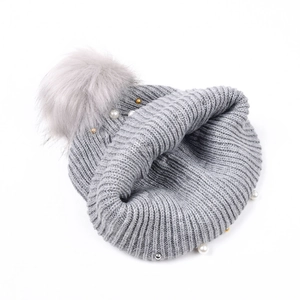 Berretto grigio in maglia con perle, perline metalliche e grande pompon in ecopelliccia