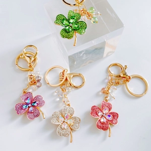 Macro view of colorful crystal-studded four-leaf clover keychains in multiple vibrant hues