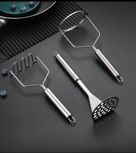 Three-piece stainless steel potato masher set with wave and hole designs on dark mat