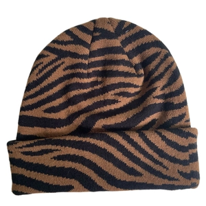 Detailed view of the tiger print knit beanie featuring a ribbed edge and soft texture