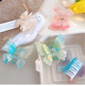 Detail view of colorful gradient butterfly hair claws in various vibrant pastel shades