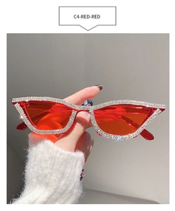 Detail shot of cat eye sunglasses featuring red lenses and sparkling silver rhinestones