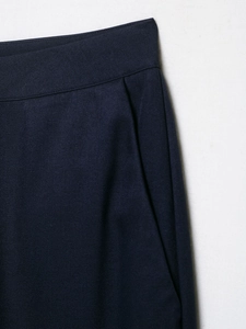 Detail of the waist structure and pocket stitching on dark blue twill trousers