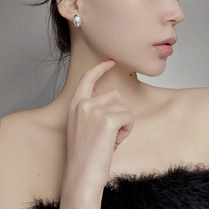 Polished silver geometric oval stud earring shown on model in a minimalist chic style