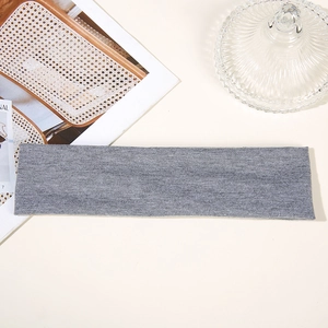 Flat lay of gray cotton sports headband on beige surface with decorative props