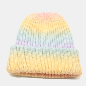 Close-up of tie-dye gradient knit beanie showing soft rainbow textures and thick yarn