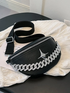 Detail of black lychee leather chest bag with silver star logo and chunky chain decoration