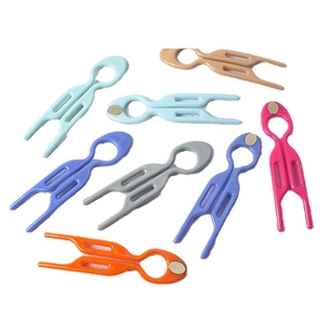 Set of colorful magnetic plastic cable clips for organized storage on white background