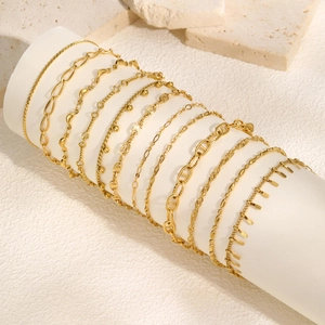 Minimalist gold stainless steel chain bracelets displayed on a white stand for women