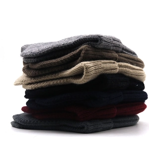 Detailed pile of multi-color ribbed knit beanies showing various autumn color options