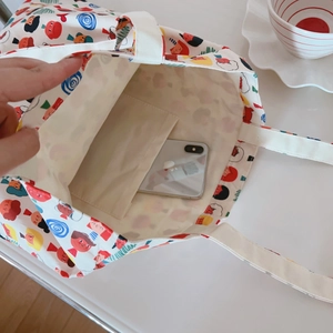 Détail de la poche intérieure ouverte et de l'imprimé dessin animé sur le sac en coton