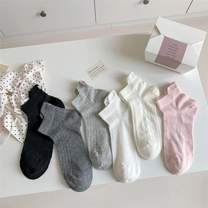 Detailed close-up of colorful cotton low-cut socks with bow patterns and ribbed texture