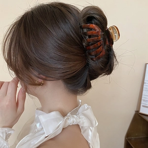 Vue détaillée d'une pince à cheveux en ambre écaillé sur le chignon d'un modèle