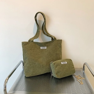 Detail of olive green corduroy tote bag set with metal chain and fashion textile label