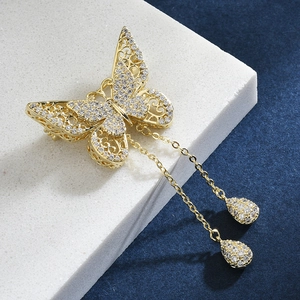 Golden butterfly brooch with sparkling crystals and elegant teardrop pendant chains