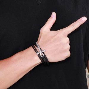Close-up of black multilayer braided leather bracelet with silver anchor charm on wrist