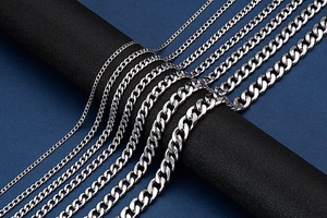 Macro view of silver stainless steel curb chains in various thicknesses on dark stand