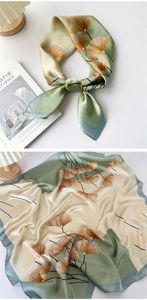 Macro shot of satin silk scarf with artistic ginkgo leaf pattern and elegant color splicing