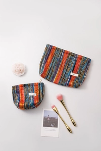 Detail shot of bohemian striped knit makeup bags with zipper and branded label